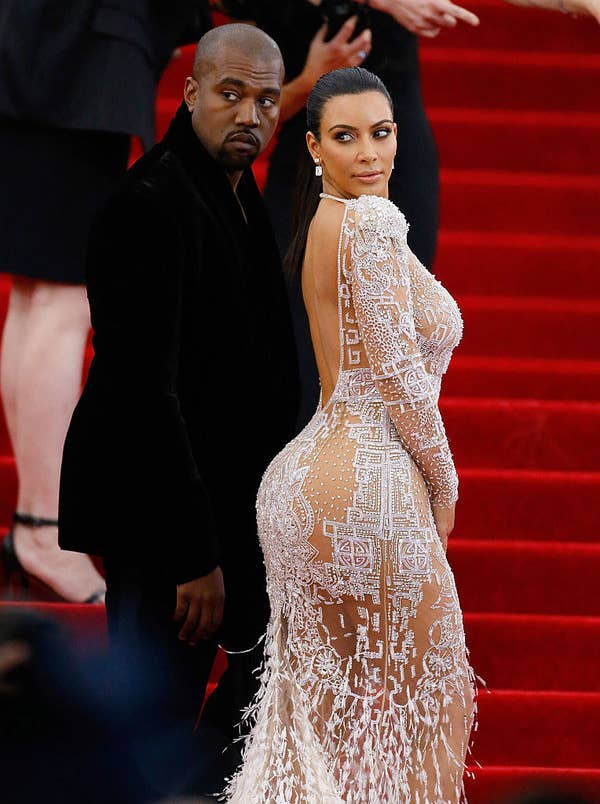 Kim Kardashian in a long-sleeved sheer gown, covered in beads and feathers