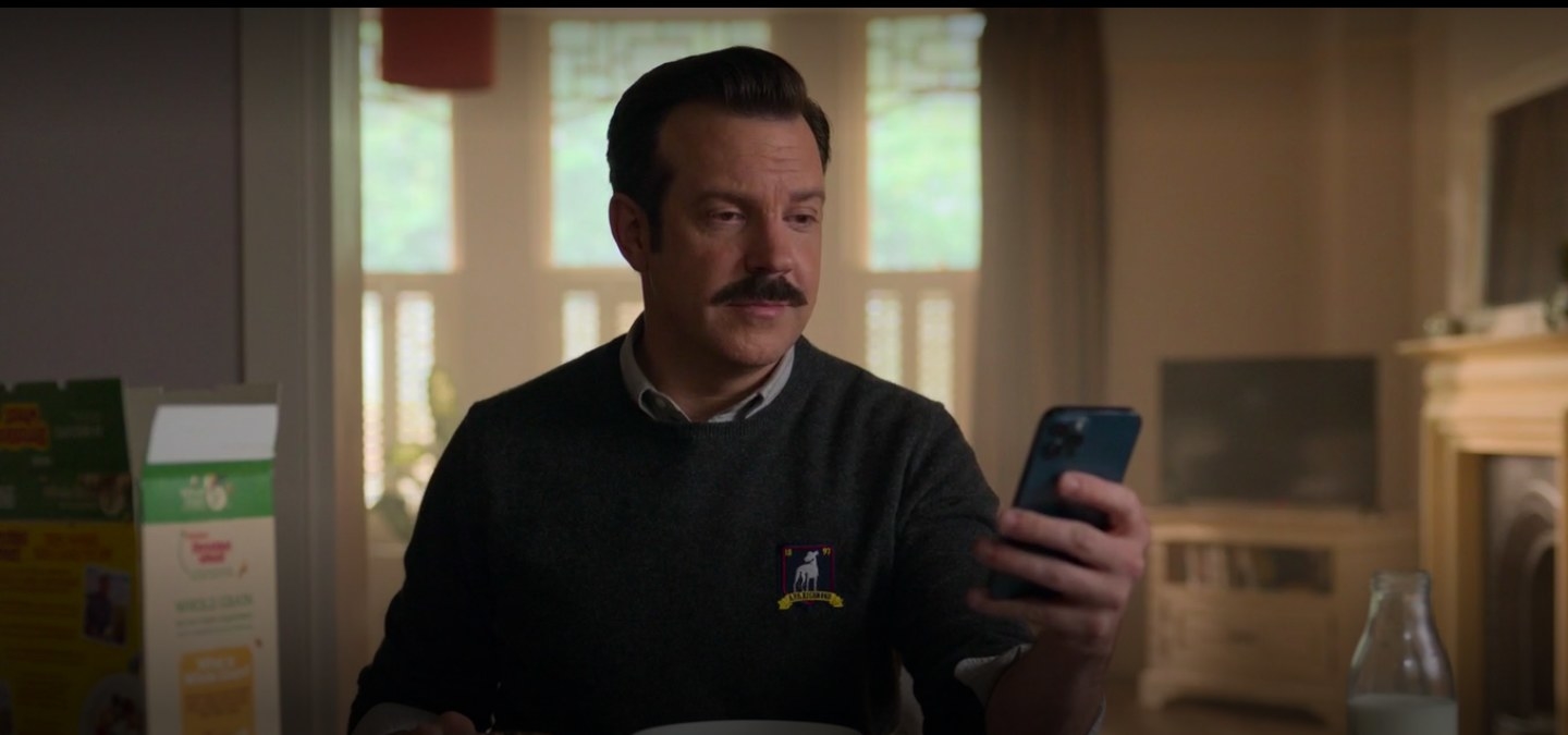 Ted looking at his phone in &quot;Ted Lasso.&quot;