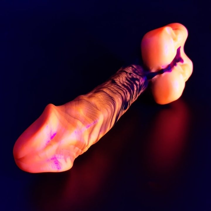 Fluorescent orange and purple realistic dildo with skulls at the base