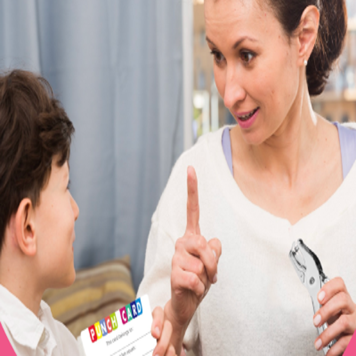 A parent smiling at their child who is holding the punch card