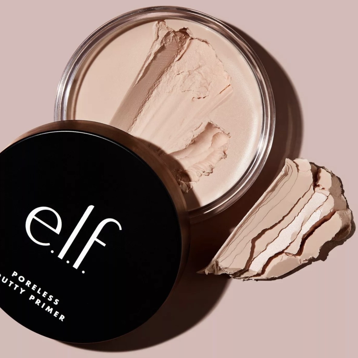 The light pink primer has chunks taken out for a texture sample and has a black lid that says &quot;e.l.f. poreless putty primer&quot;