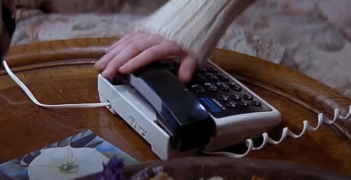 Screenshot from Scream of Drew Barrymore&#x27;s hand about to pick a the house phone