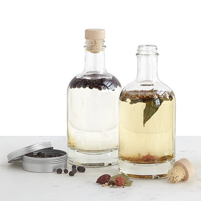 Product image of a silver tin with dried botanicals and two glass jugs of gin