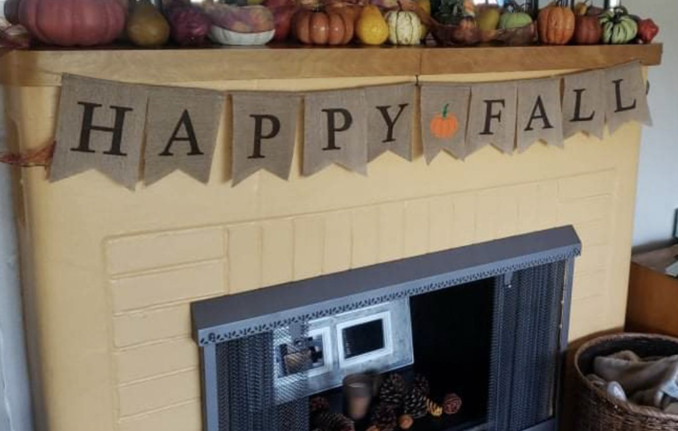 Burlap letters on a string printed to say &quot;Happy Fall&quot; with a pumpkin in the middle of the words