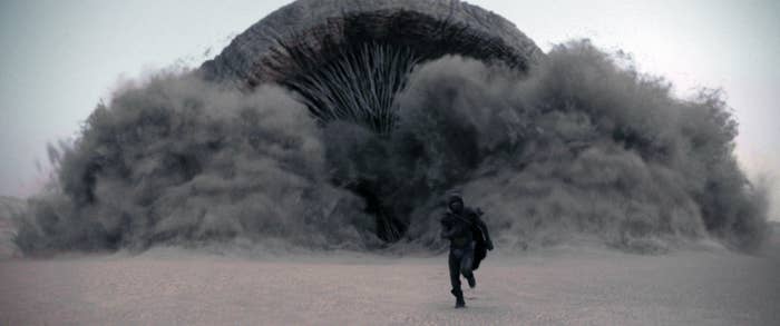 Person running from a giant sandworm