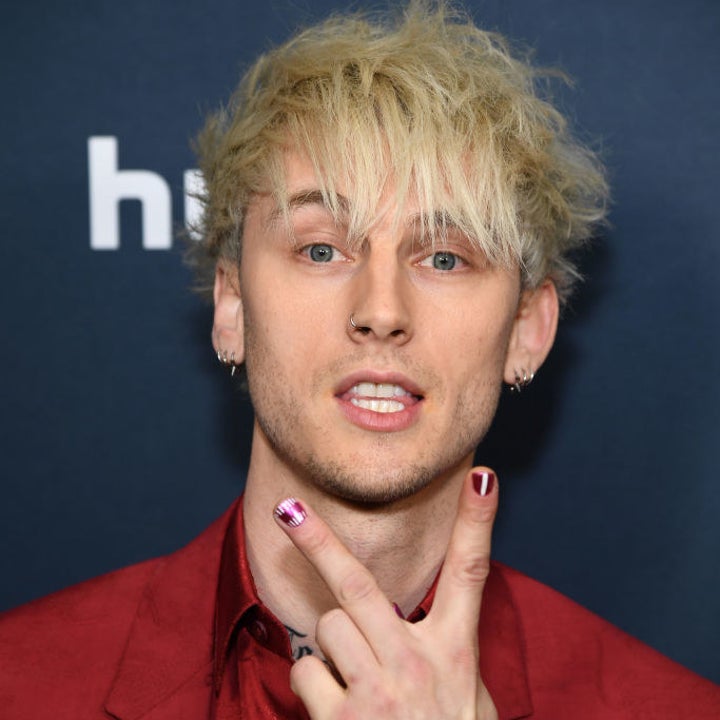 Machine Gun Kelly giving the peace sign at an event