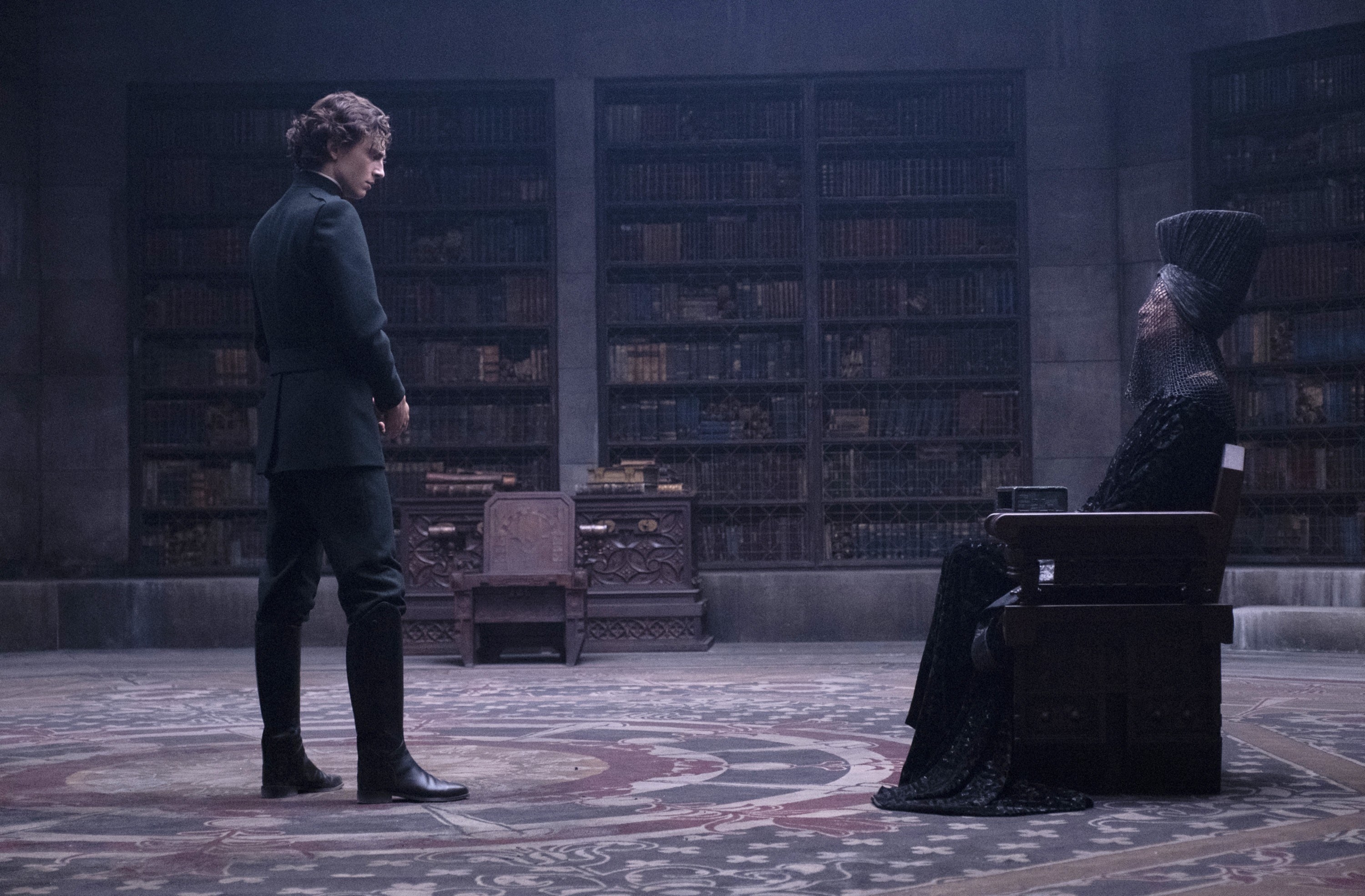 The mother superior (Charlotte Rampling) sitting in an old library talking to Paul