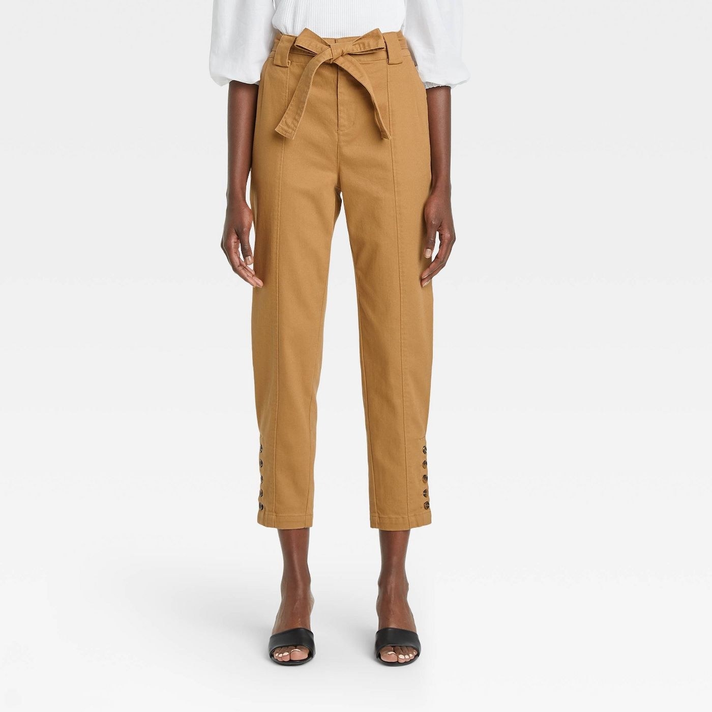 Model wearing the brown pair of button hem ankle-length pants