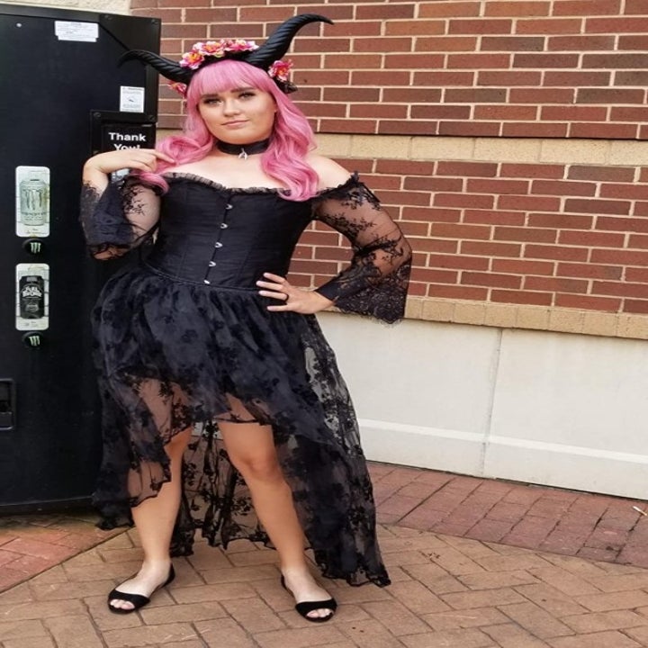 a reviewer wearing the dress with horns