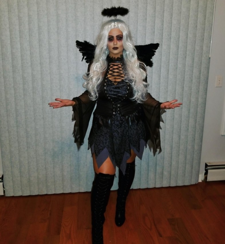 a reviewer wearing the costume with a black corset and bell sleeves