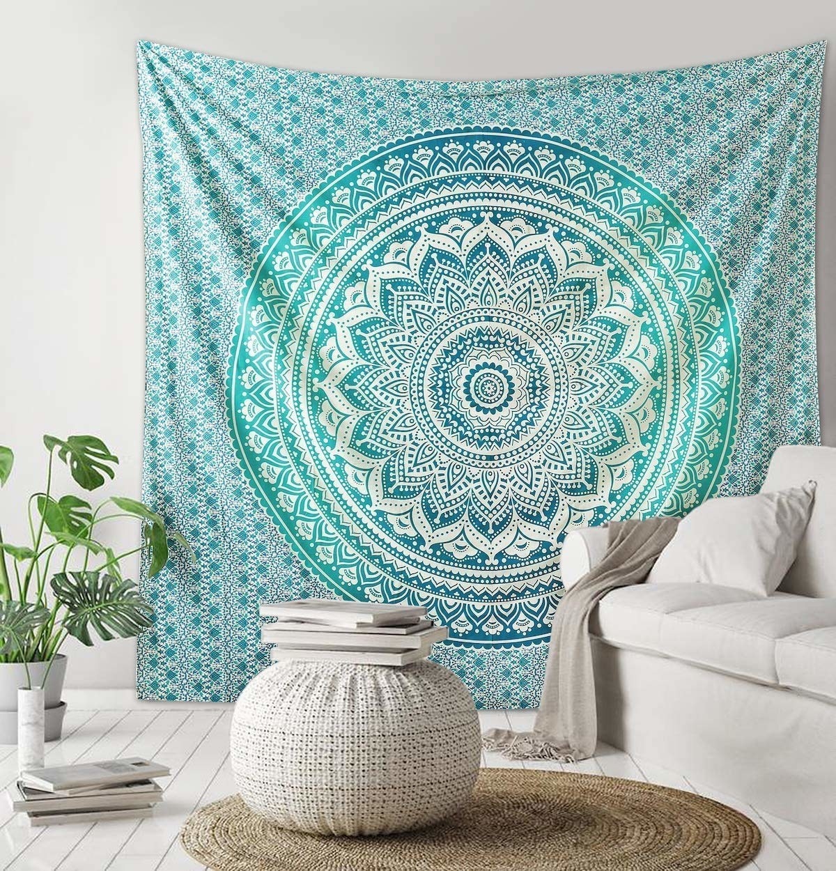 A blue tapestry on a wall next to a pouf and a rug