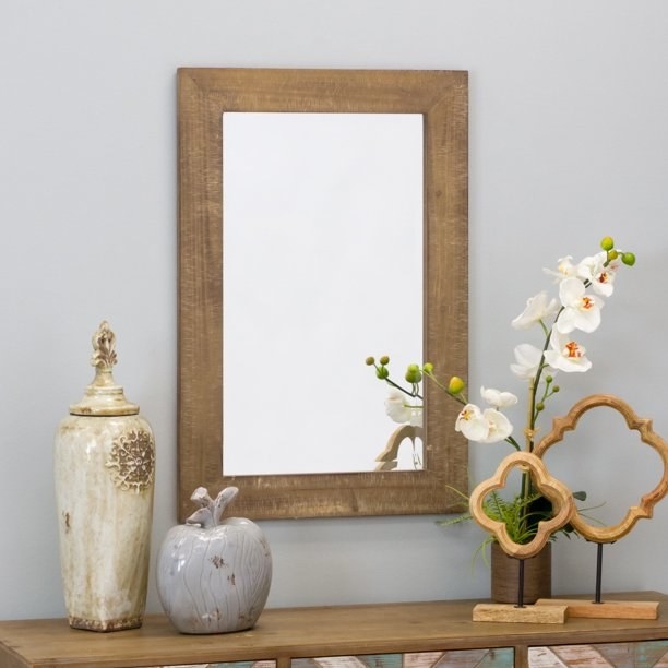 The mirror hangs above an entryway table.