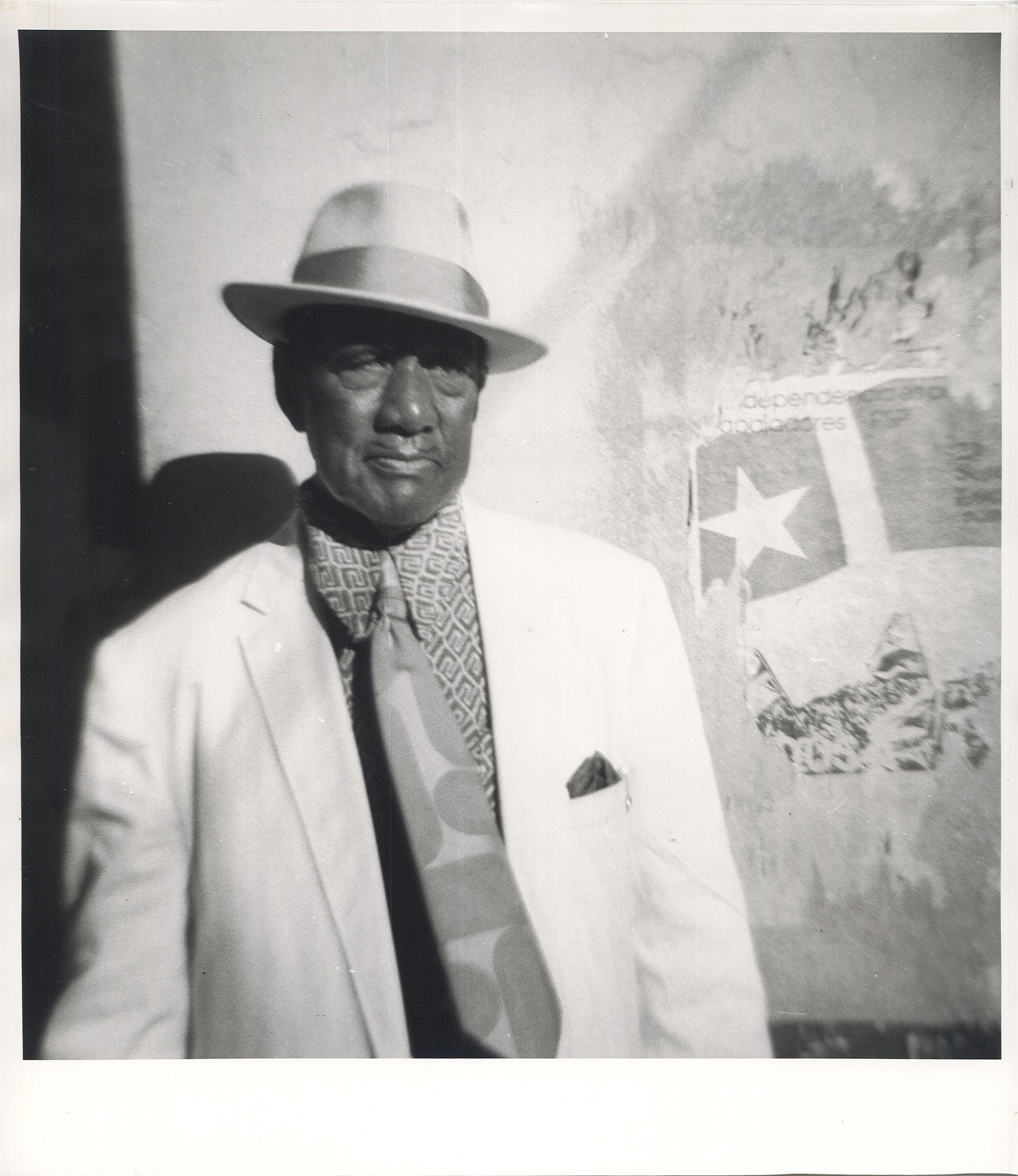 An older man in a fedora, suit and tie