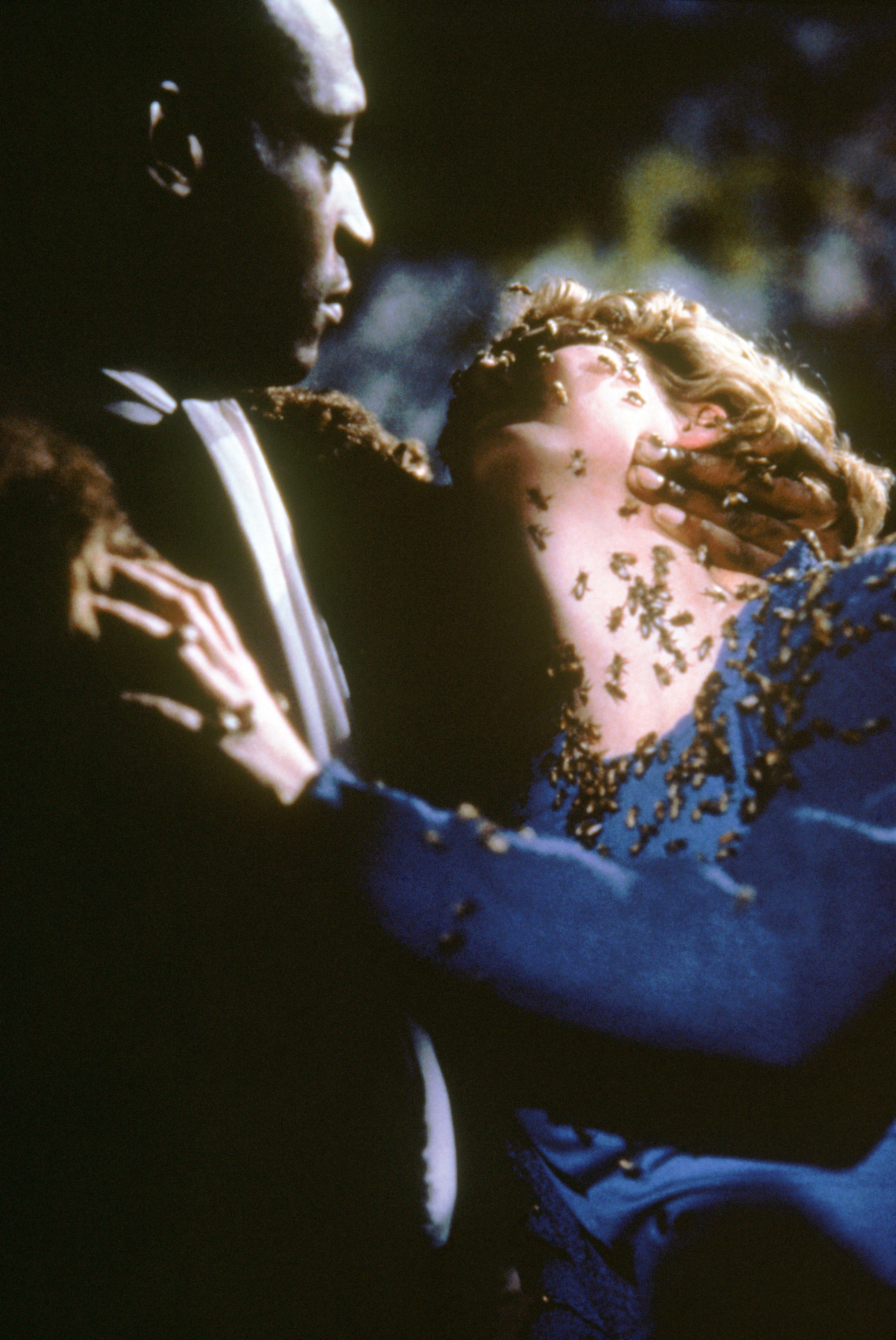 Candyman embracing a woman covered with bees