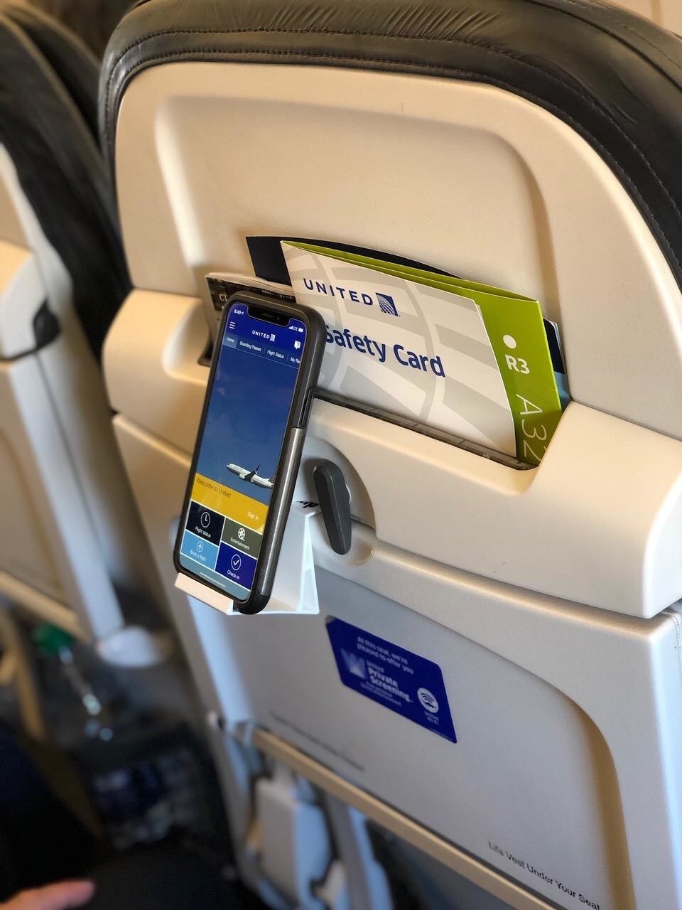 reviewer image of a phone mounted in the SkyClip on a plane