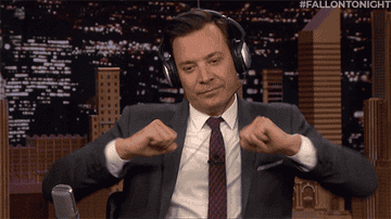 Jimmy Fallon wearing headphones and dancing in his chair