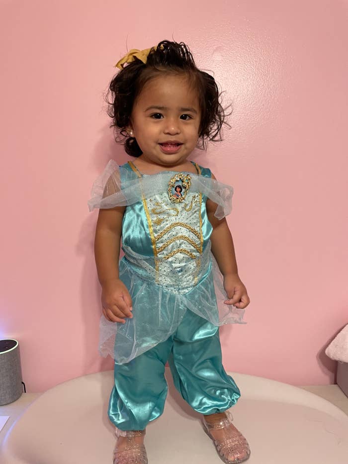 a toddler in a blue satin jasmine costume