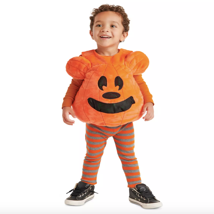 a toddler in a shirt that has a 3d mickey pumpkin on it