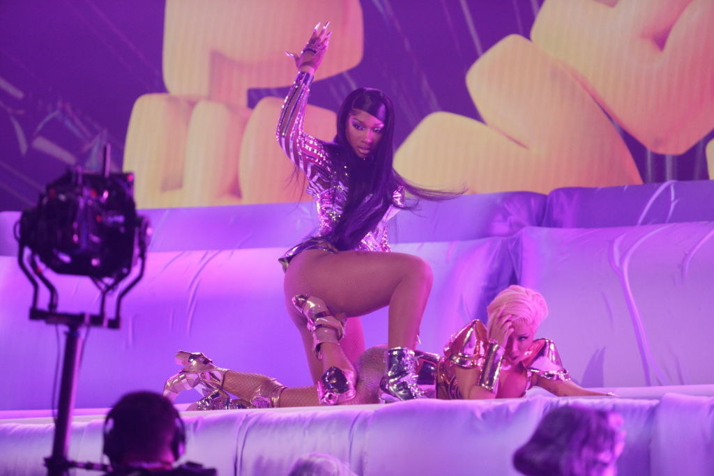 Megan Thee Stallion kneeling over Cardi as they perform at the Grammys