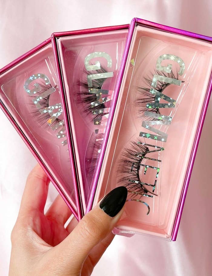 A person holding three packs of lashes