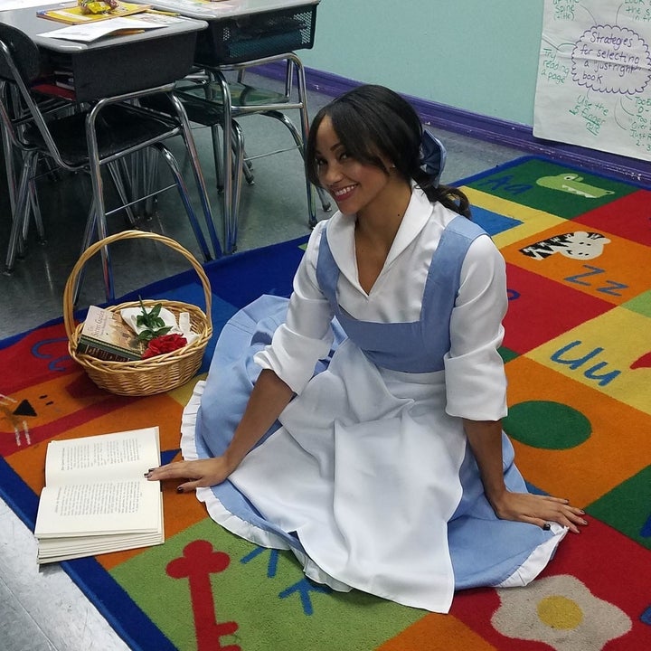 a reviewer sitting on the floor in belle's villager costume