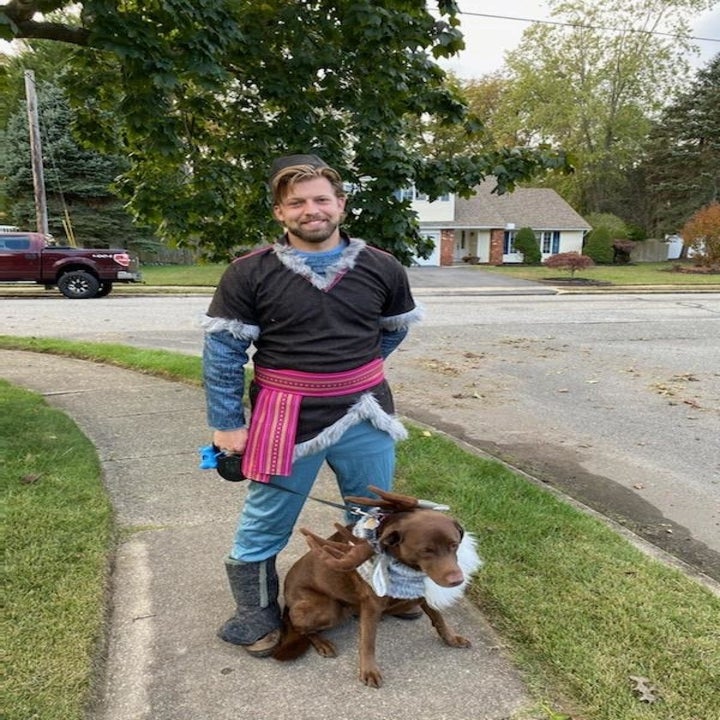 a reviewer in the kristoff costume walking his dog who is dressed as sven