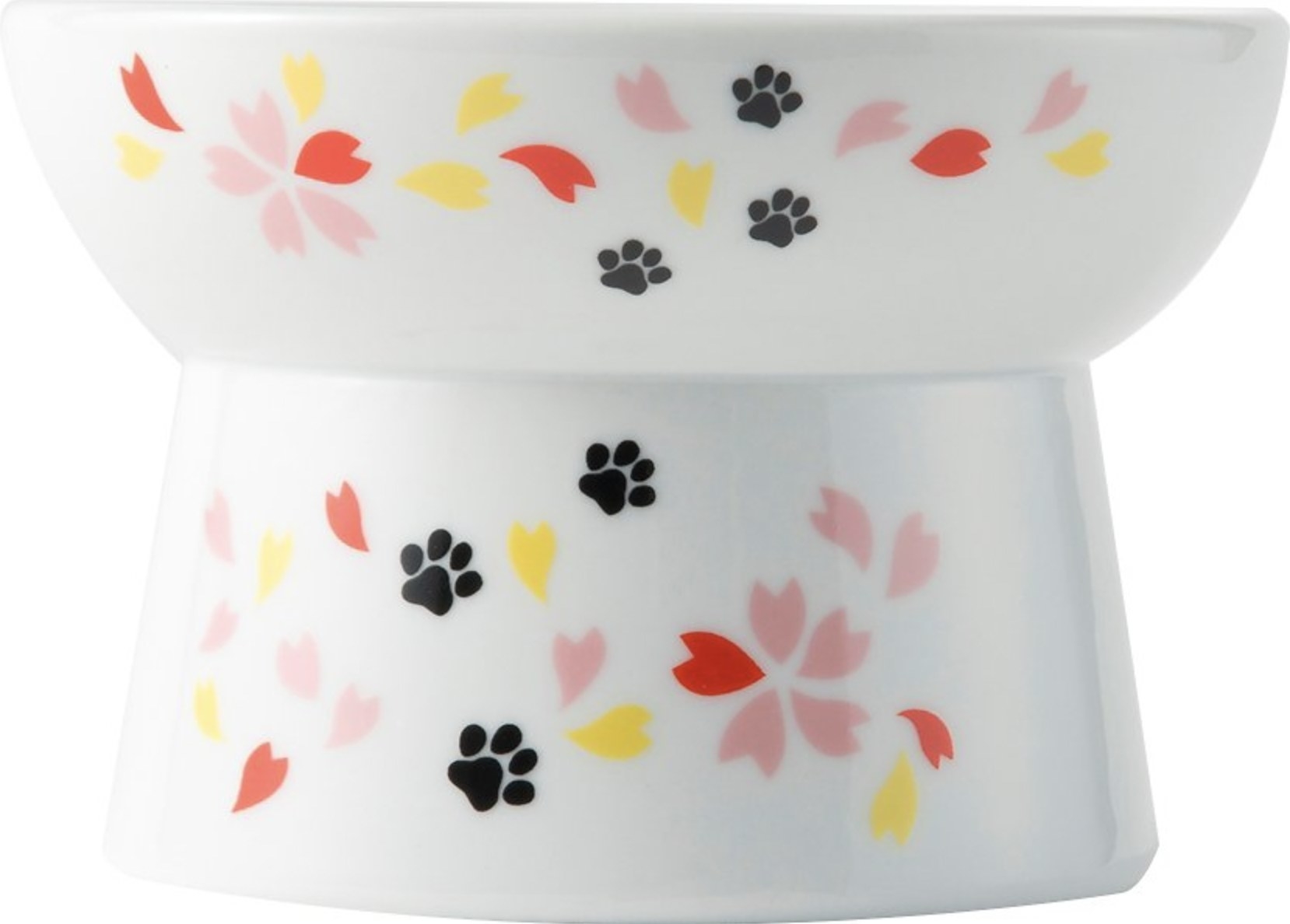 a raised food bowl with black paw prints and red, pink, and yellow leaves