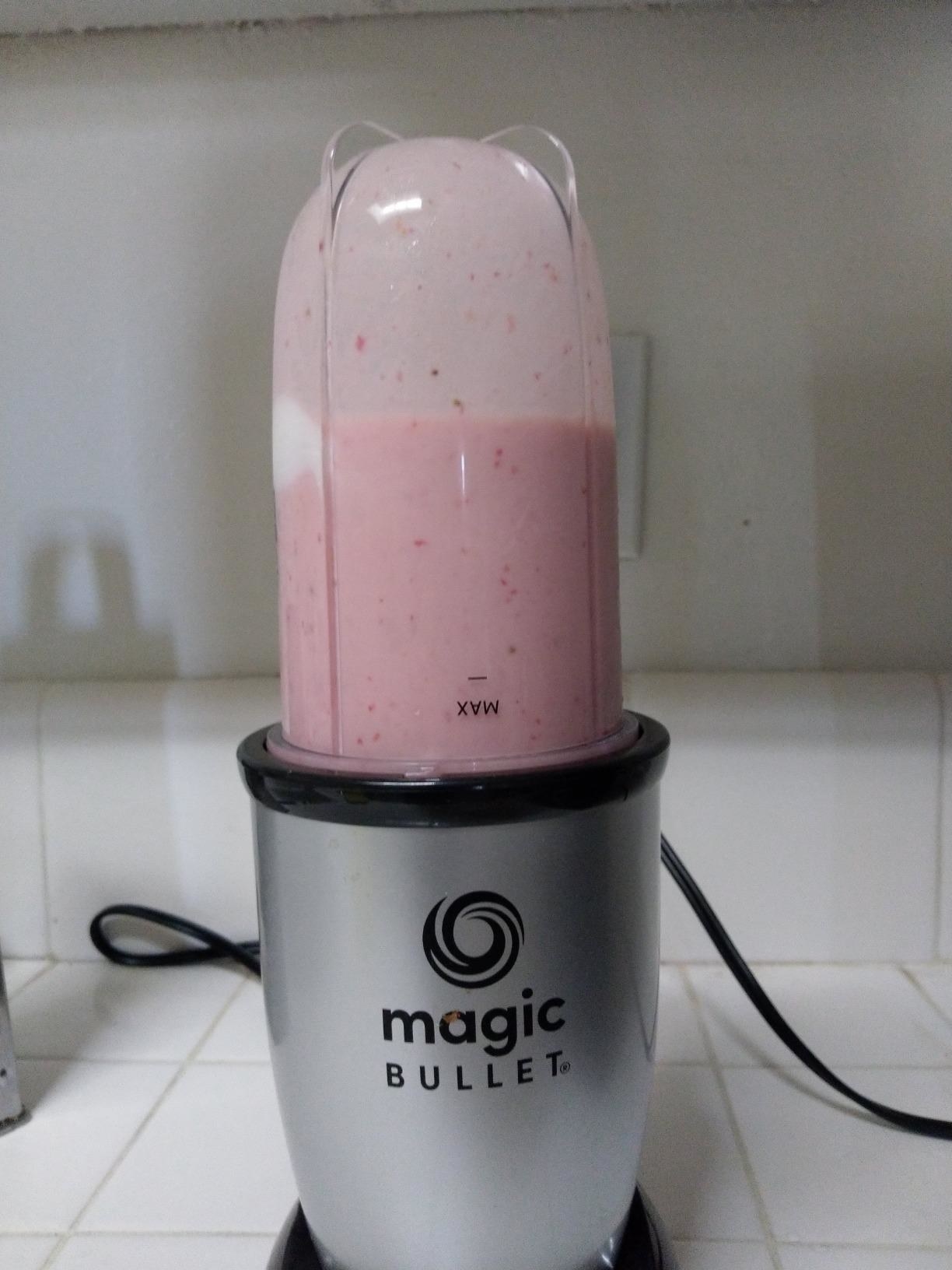 the blender with a pink smoothie inside