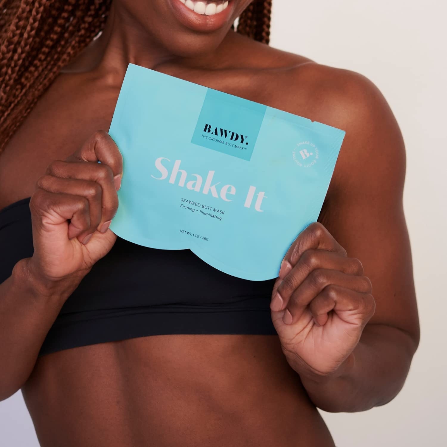 Model holding up the shake it butt mask