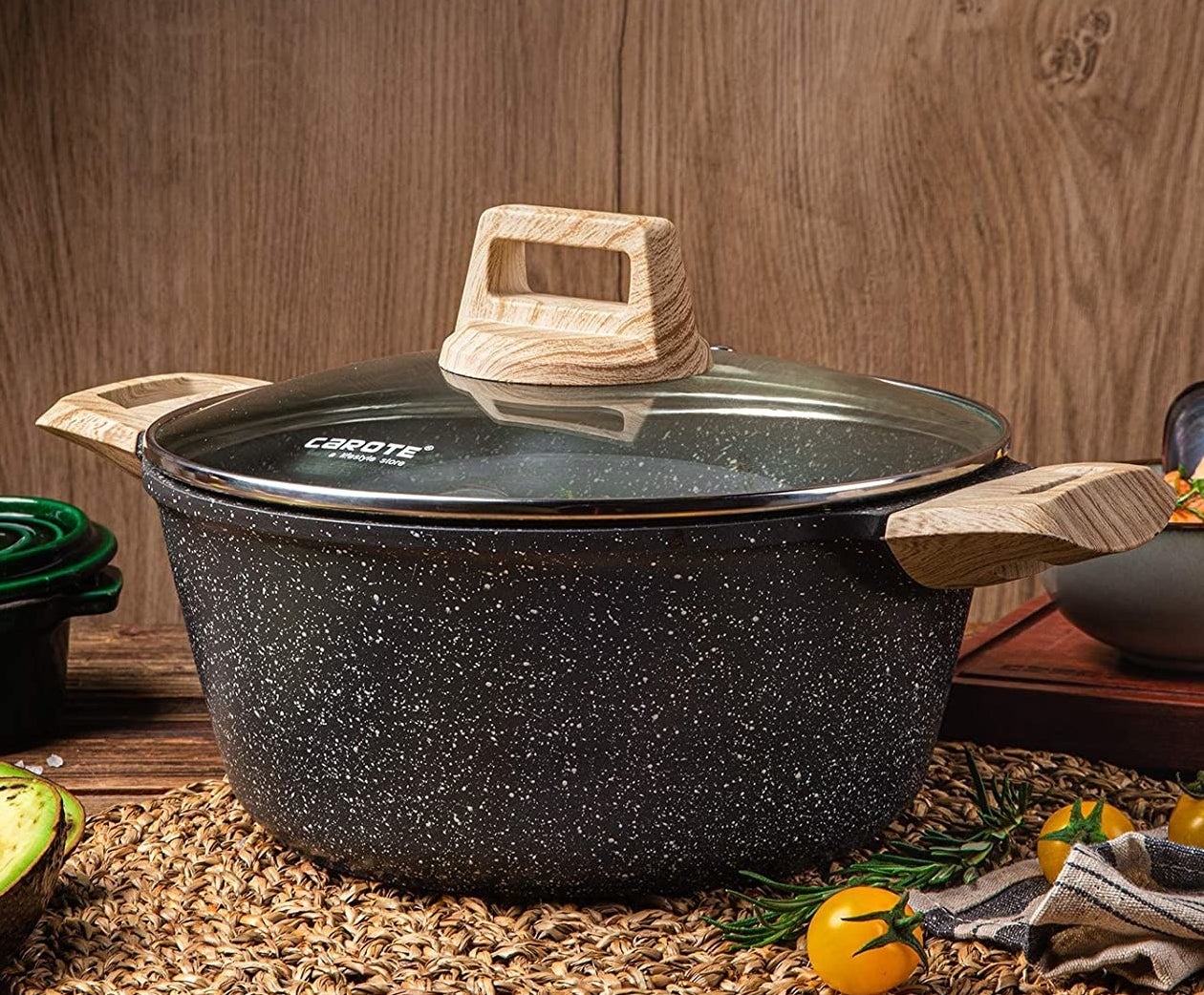 Product photo of black and white speckled dutch oven with wooden handles and a glass cover