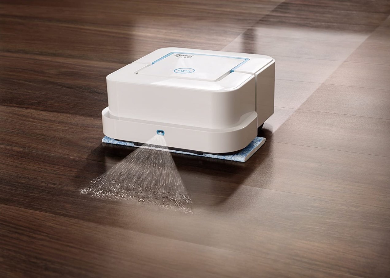 the small robot vacuum spraying water and mopping up hardwood floors