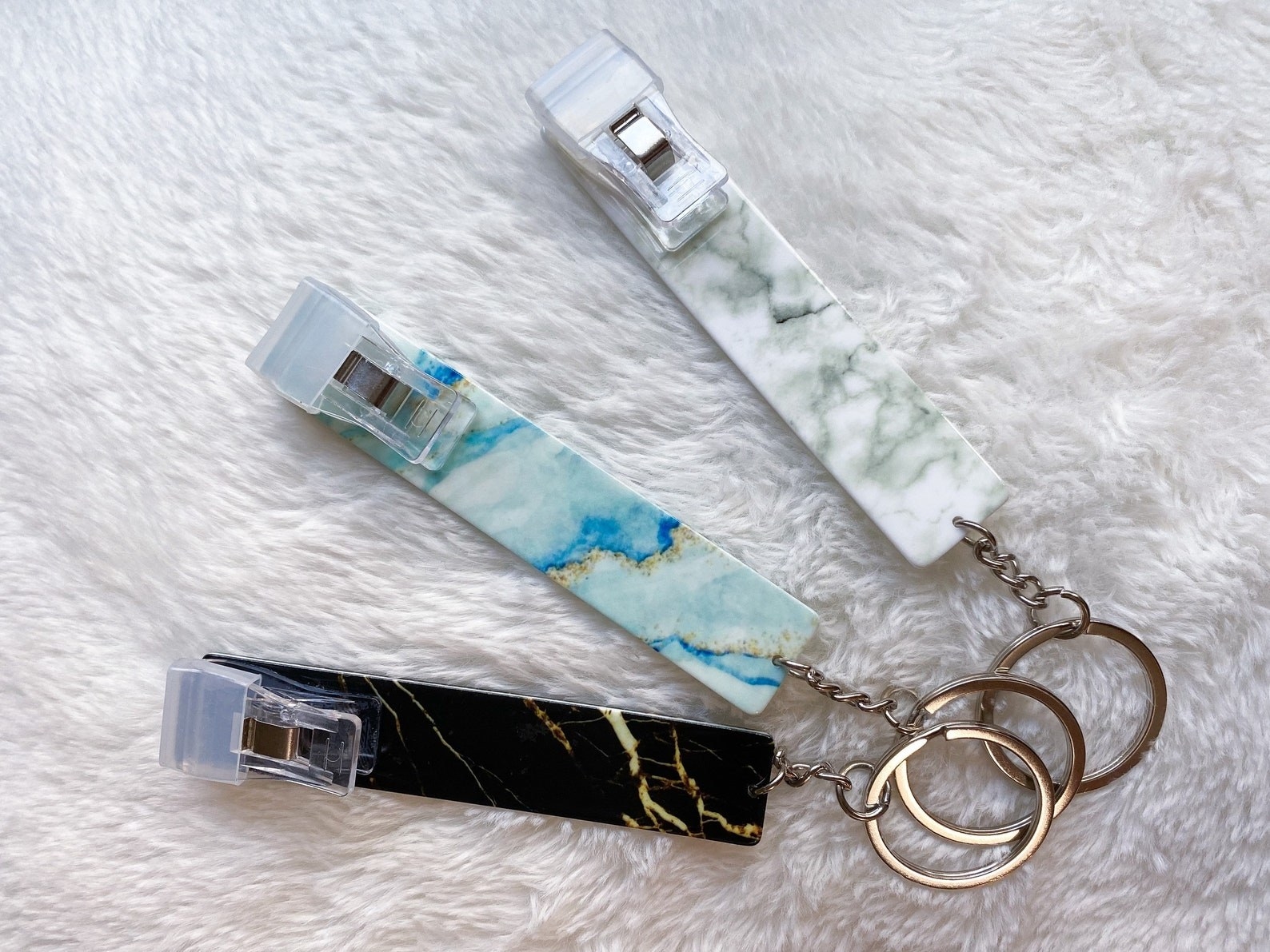 three long rectangular card grippers on keychains and in different metallic colors