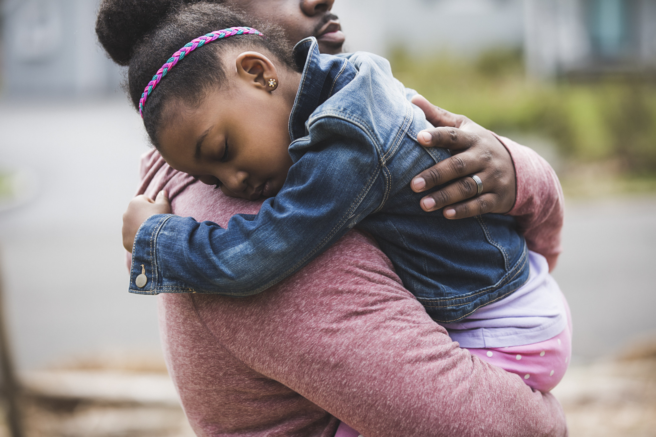 A father carries his sleeping child