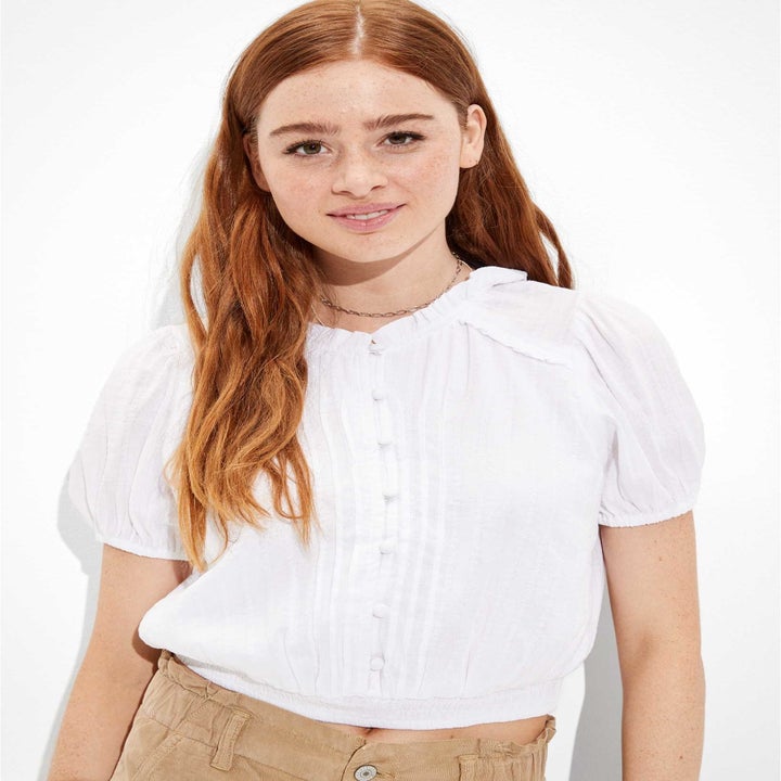 Model in smocked button up white short sleeve blouse