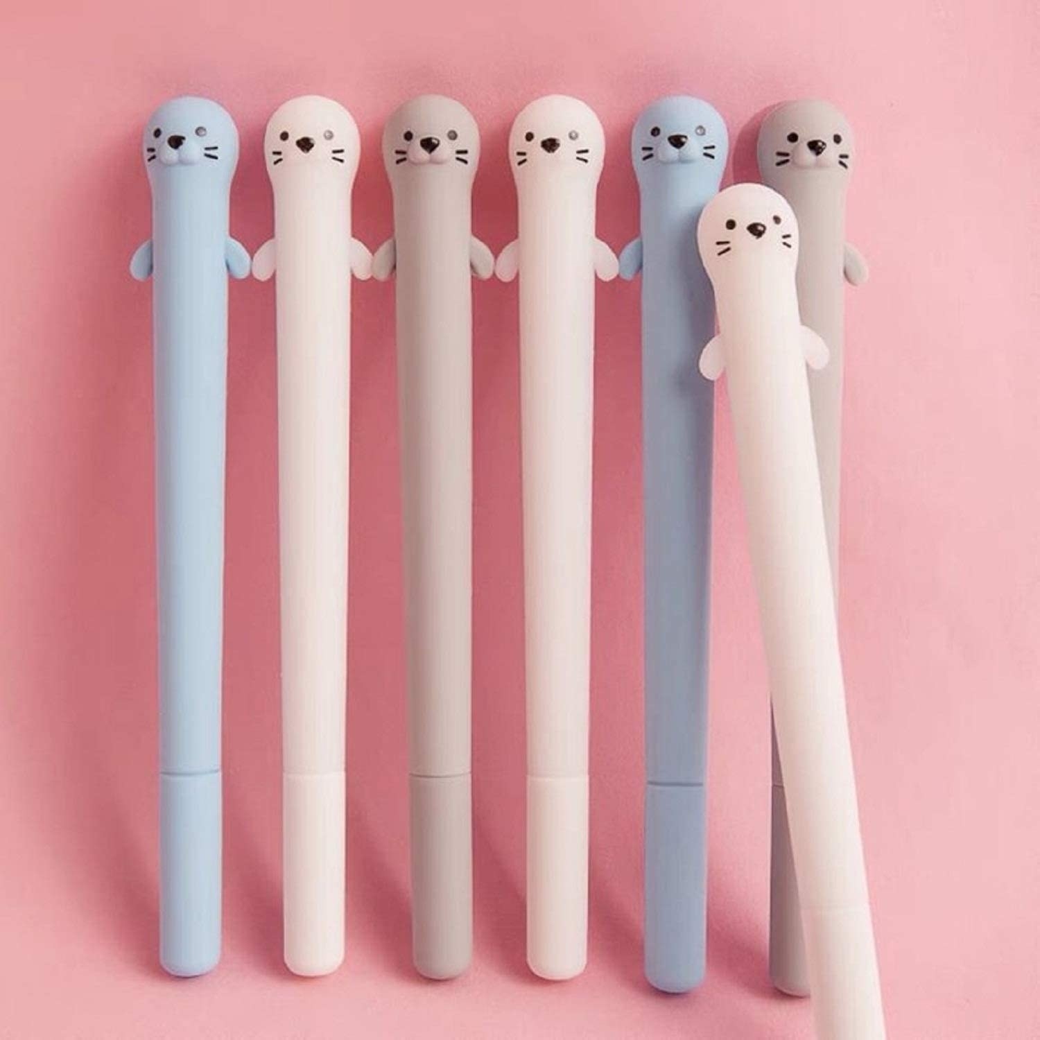 a set of seven pens with caps that look like cute otters