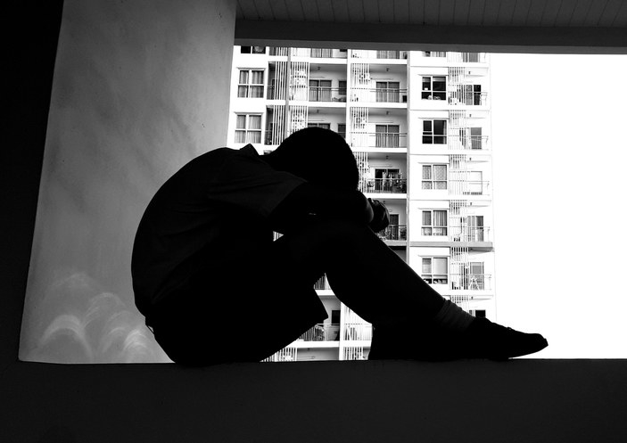 A young boy sits alone, scared