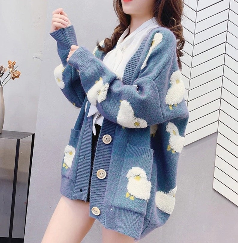 a model wearing the sheep cardigan in blue which has oversized buttons