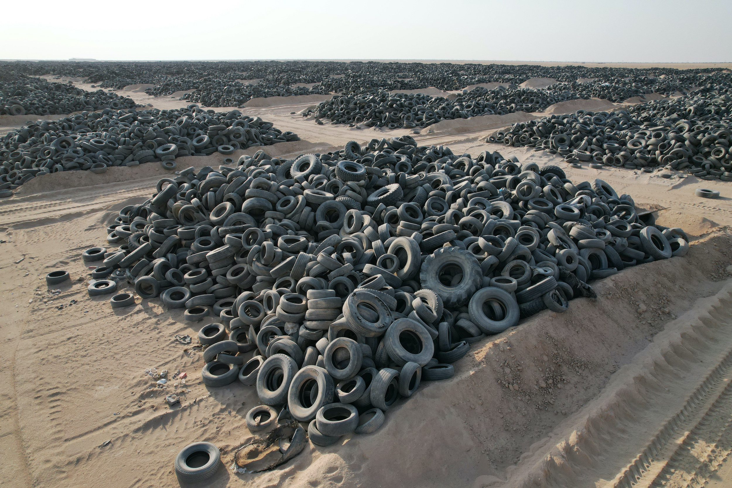 Thousands of tires sit in piles of sand in a remote area of the Middle East