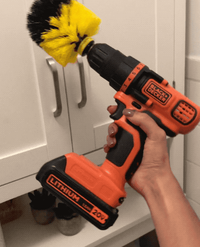 former buzzfeed editor holding a Black & Decker drill with the brush attached