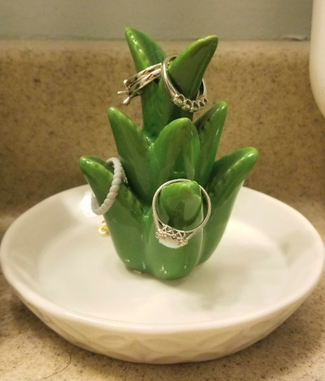 reviewer&#x27;s ceramic dish that has a white small plate-style bottom and an aloe shaped fixture in the middle with rings hanging from each branch of aloe