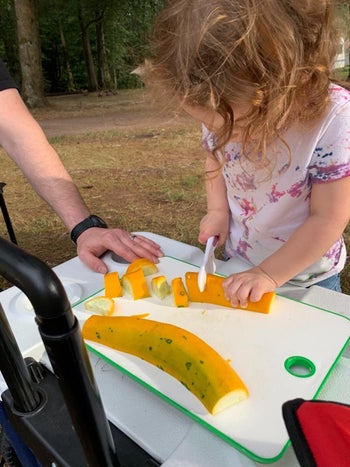 Reviewer's child slicing a squash with the knife