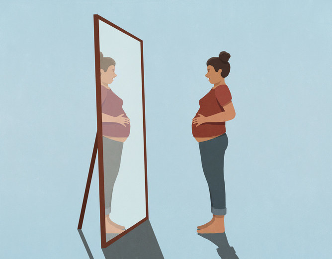 women carrying baby looking in mirror at belly
