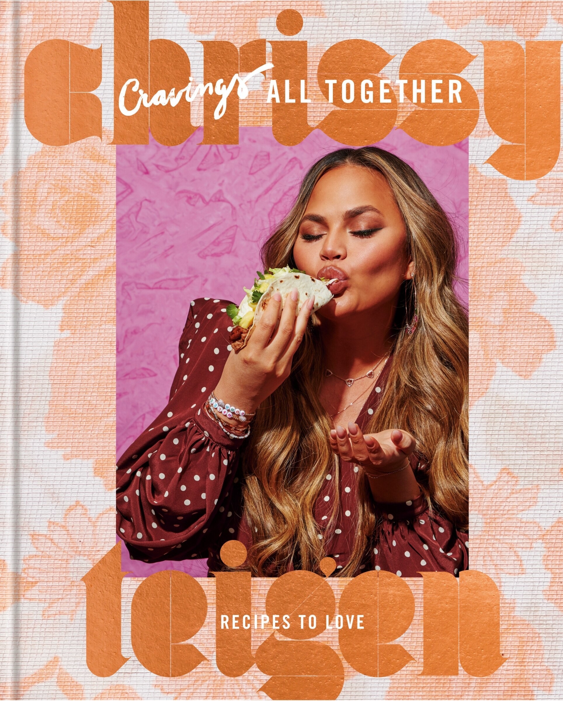 The cover of the cookbook with a picture of Chrissy Teigen eating a taco
