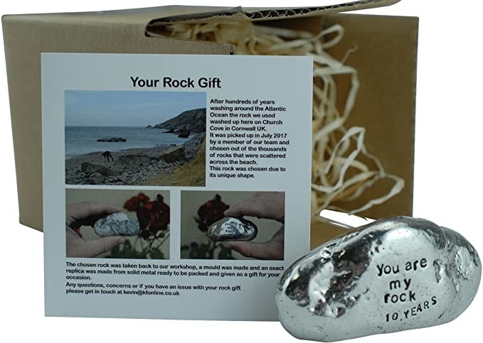 Product photo of silver rocked shaped tin that reads "you are my rock 10 years" in front of box with straw and card that says "your rock gift"