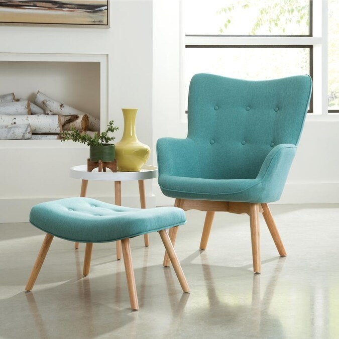 Teal chair and ottoman with a small end table and a fireplace in the background
