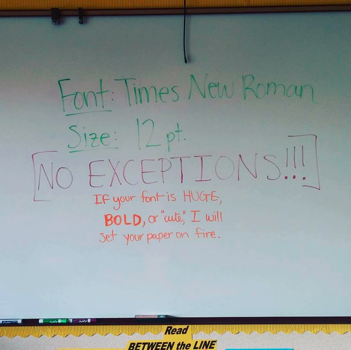 A white board that reads: &quot;Font: Times New Roman, Size: 12 point, no exceptions; if your font is huge, bold, or &#x27;cute,&#x27; I will set your paper on fire&quot;