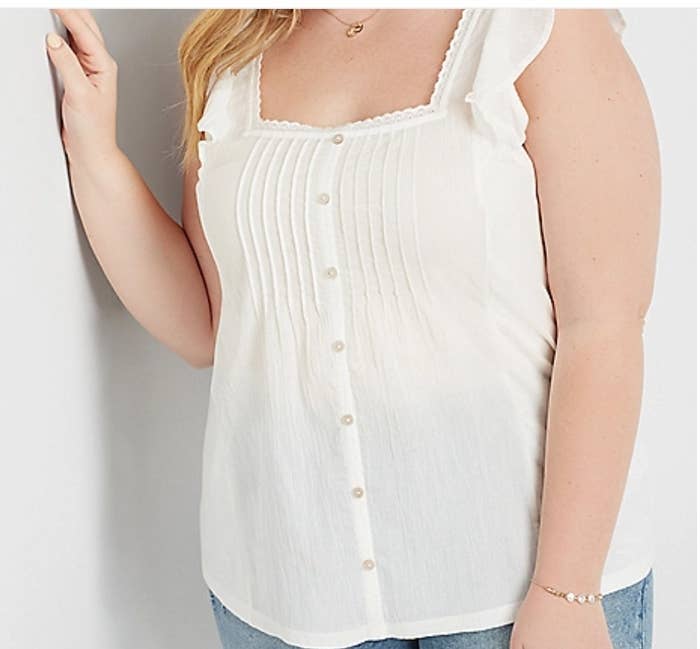 Model wearing white button down top