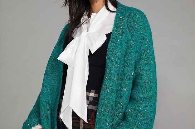 modwel wearing the green sweater over a black and white top and plaid pants