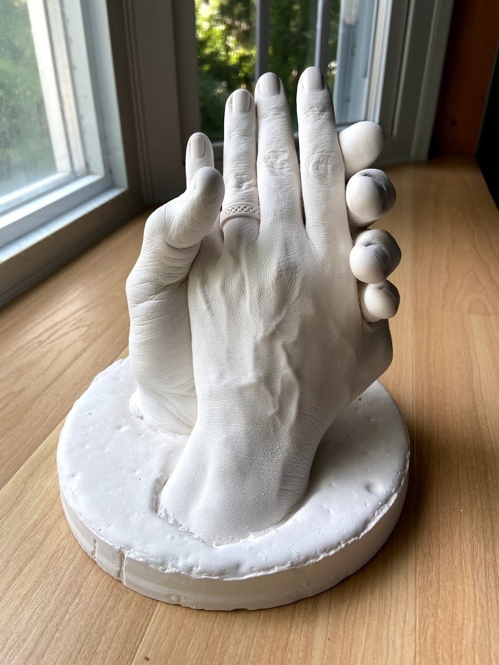 Reviewer image of holding hands made of white plaster\
