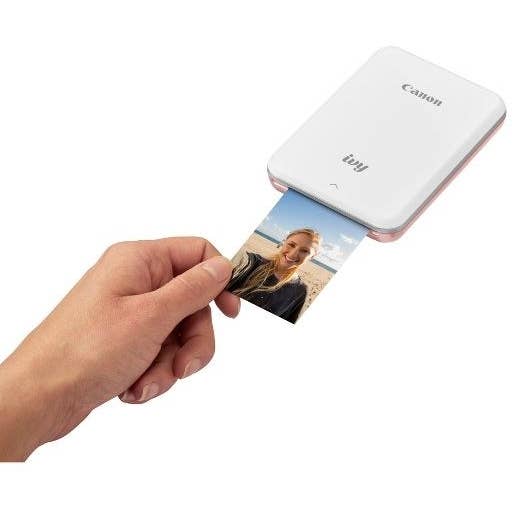 Hand reaching for photo printing from Canon mini smartphone printer